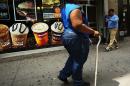 An obese woman walks in a Brooklyn neighborhood on June 11, 2013 in New York City