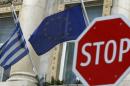 The Greek and EU flags are seen behind a stop sign in front of the Greek embassy in Vienna
