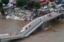 An aerial view shows people walking on a collapsed bridge in Acapulco
