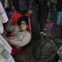 An injured Indian woman who survived a stampede on a railway platform is carried away at the main railway station in Allahabad, India, Sunday, Feb. 10, 2013. At least ten Hindu pilgrims attending the Kumbh Mela were killed and more then thirty were injured in a stampede on an overcrowded staircase, according to Railway Ministry sources.  (AP Photo/Kevin Frayer)