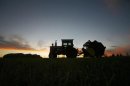 A tractor is silhouetted on a hillside in Prairie City