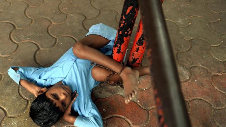Nine year old Indian boy Lakhan Kale is tied with a cloth rope around his ankle, to a bus-stop pole in Mumbai, May 20, 2014