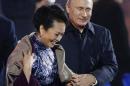 In this Nov. 10, 2014 file photo, Russia's President Vladimir Putin, right, puts a shawl on Peng Liyuan, left, wife of Chinese President Xi Jinping as they arrive to watch a fireworks show after a welcome banquet for the Asia Pacific Economic Cooperation (APEC) summit in Beijing. It was a warm gesture on a chilly night when Vladimir Putin wrapped a shawl around the wife of Xi Jinping while the Chinese president chatted with Barack Obama. The only problem: Putin came off looking gallant, the Chinese summit host gauche and inattentive. (AP Photo, File) CHINA OUT