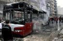 This image provided by Aleppo Media Center AMC which has been authenticated based on its contents and other AP reporting, shows Syrians inspecting a burnt bus after a missile fired by Syrian government aircraft hit the vehicle in the rebel-held neighborhood of al-Bab in Aleppo, Syria, Tuesday, Dec. 31, 2013. The bus was full of people when it was struck, setting it on fire and killing several people, activists said.. (AP Photo/Aleppo Media Center AMC)