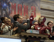 Actor Robert Downey Jr. gives a high-five to his "Iron Man" character during opening bell ceremonies of the New York Stock Exchange, Tuesday, April 30, 2013. Stock prices are opening mostly lower on Wall Street as weak earnings from Pfizer and other companies drag down major market averages. Downey's film, "Iron Man 3," also starring Don Cheadle and Gwyneth Paltrow, opens nationwide on May 3. (AP Photo/Richard Drew)