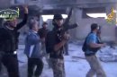 In this image from amateur video obtained by a group which calls itself Ugarit News, shows rebel fighters celebrating after purportedly capturing an army base in Nairab, northwestern Syria, Thursday, May 23, 2013. The video is consistent with independent AP reporting. Rebel fighters captured an army base late Wednesday, a rare victory after a series of battlefield setbacks, the Britain-based Syrian Observatory for Human Rights, a pro-opposition group said. The group said scores of pro-regime troops and more than a dozen rebels were killed in the battle for the base, near the northwestern town of Nairab. (AP Photo/Ugarit News via AP video)