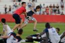 Cyril Praud, physical therapist for French team, runs after a soccer fan storming the pitch at the end of a training session at the Santa Cruz Stadium, in Ribeirao Preto, Brazil, Friday, June 13, 2014. France will play in group E of the 2014 Brazil soccer World Cup. (AP Photo/David Vincent)