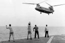 In this April 29, 1975 photo provided by courtesy of American Experience and Hugh Doyle, aboard the USS Kirk, crew members signal the Chinook to hover over the deck and drop its passengers out. The new documentary film, "Last Days in Vietnam," directed and produced by Rory Kennedy, recounts the dramatic events surrounding the 1975 military evacuation of Saigon during the Vietnam War. The film releases on Friday, Sept. 5, 2014. (AP Photo/Courtesy American Experience, Courtesy Hugh Doyle)