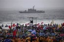 Pilgrims cheer as policemen patrol on deck and Brazilian Navy ship patrols coast ahead World Youth Day in Rio de Janeiro