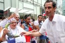 Anthony Weiner, running in the New York Mayors race, right, reacts after sharing a moment with a spectator and her plantains, left, as he takes part in the Dominican Day Parade on New York's Avenue of the Americas Sunday Aug. 11, 2013. (AP Photo/Tina Fineberg)