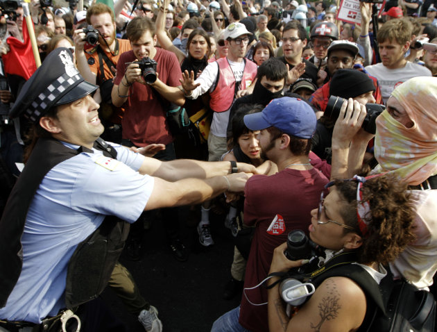 Demonstrators make a futile attempt to stop a Chicago police officer from detaining a protester during this weekend's NATO summit in Chicago Sunday, May 20, 2012 in Chicago. (AP Photo/Seth Perlman)