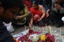 Ciudadanos indios rezan frente a unas velas instaladas tras la incineración de la joven violada, este domingo