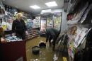 Shopkeepers Donald and Irene Irving bail floodwater out of their shop after the River Nith burst its banks in Dumfries, southern Scotland, on December 30, 2015