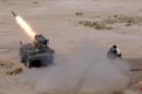 Members of Iraq's Shi'ite paramilitaries launch a rocket towards Islamic State militants in the outskirts of the city of Falluja, in the province of Anbar