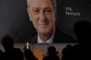 Designated successor Reinhardt is seen on a huge TV screen as outgoing utgoing Chairman of Swiss drug maker Novartis Vasella addresses the the annual shareholders general meeting in Basel