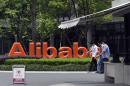 FILE - In this May 21, 2012 file photo, men walk past the corporate logo at the headquarters compound of Alibaba Group in Hangzhou in eastern China's Zhejiang province. Alibaba Group is aiming to raise $1 billion in a long-awaited IPO likely to have ripple effects across the Internet. The Tuesday, May 6, 2014 filing sets the stage for the technology industry's biggest initial public offering since short messaging service Twitter and its early investors collected $1.8 billion in its stock market debut last fall. (AP Photo/File) CHINA OUT