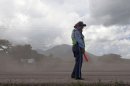 A Nicaraguan National Police officer patrols on a road blanketed with volcanic ash spewed from the San Cristobal volcano, near Chinandega, Nicaragua, Saturday, Sept. 8, 2012. Nicaragua's tallest volcano, located about 70 miles (110 kilometers) northwest of Managua, near the Honduran border, has let off a series of explosions, spewing gases and showering ash on nearby towns, prompting an evacuations of residents. (AP Photo/Esteban Felix)