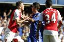 Chelsea's Oscar, centre, holds back Arsenal's Gabriel who had been show a red card for a second clash with Chelsea's Diego Costa after during the English Premier League soccer match between Chelsea and Arsenal at Stamford Bridge stadium in London, Saturday, Sept. 19, 2015. Chelsea won the game 2-0.(AP Photo/Alastair Grant)