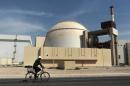 FILE - In this Oct. 26, 2010 file photo, a worker rides a bicycle in front of the reactor building of the Bushehr nuclear power plant, just outside the southern city of Bushehr. Iran left the negotiating table in Lausanne, Switzerland, on Thursday, Aoril 2, 2015 with a commitment to implement the Additional Protocol, IAEA's most potent monitoring instrument. (AP Photo/Mehr News Agency, Majid Asgaripour, File)