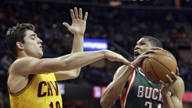 Milwaukee Bucks&#39; Giannis Antetokounmpo (34), from Greece, tries to shoot against Cleveland Cavaliers&#39; Joe Harris (12) during an NBA basketball game Wednesday, Dec. 31, 2014, in Cleveland. (AP Photo/Tony Dejak)