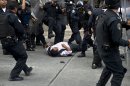 Riot police beat a teacher during a protest against the educational reforms in Mexico City on September 11, 2013