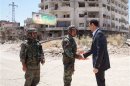 Syria's President Bashar al-Assad shakes hands with a military personnel during his visit to a military site at Darya