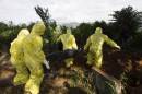 Burial team prepare body of Ebola Virus victim for interment in Freetown