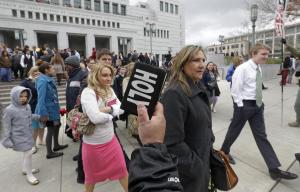 People walk pass a unidentified protester with a bible …