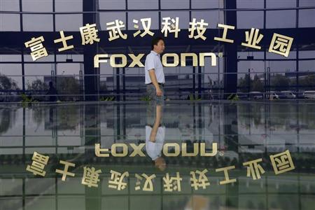 A man walks past a logo of a Foxconn factory in Wuhan, Hubei province, August 31, 2012. REUTERS/Stringer