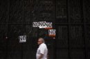 A man walks past posters after a civil servants' protest against government austerity measures in Madrid
