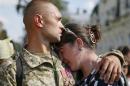 A man embraces his girlfriend in Kiev as they commemorate Ukrainian servicemen killed a year ago during fights with pro-Russian rebels near Ilovaysk in eastern Ukraine