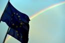 A rainbow is seen behind European flags during a euro zone EU leaders emergency summit in Brussels