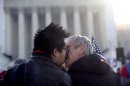 Wyatt Tan, left and Mark Nomadiou, both of New York City, kiss in front of the Supreme Court in Washington, Wednesday, March 27, 2013, prior to the start of a court hearing on the 1996 Defense of Marriage Act (DOMA). In the second of back-to-back gay marriage cases, the Supreme Court is turning to a constitutional challenge to the law that prevents legally married gay Americans from collecting federal benefits generally available to straight married couples. (AP Photo/Carolyn Kaster)