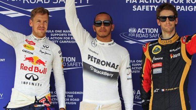 Lewis Hamilton (C) of Britain waves with Red Bull Formula One driver Sebastian Vettel (L) of Germany and Lotus F1 Formula One driver Romain Grosjean (R) of France after taking the pole position in the qualifying session of the Hungarian F1 Grand Prix (R)