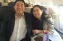 In this photo provided by the David House Agency, an international crisis firm, American couple Matthew, left, and Grace Huang, smile while aboard an airliner following their departure from the Gulf Arab nation of Qatar on Wednesday, Dec. 3, 2014, . The Los Angeles couple had been detained in the country after their arrest in January 2013, on murder charges following the death of their 8-year-old daughter Gloria, who was born in Ghana. (AP Photo/The David House Agency)