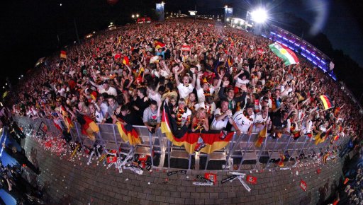Soccer fans react during a public screening as Germany scores a goal against Italy while watching the Euro 2012 semi-final soccer match in Berlin