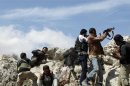 Free Syrian Army fighters fire their weapons during what they said were clashes with forces loyal to Syria's President al-Assad at Al-Arbaeen mountain in Idlib countryside