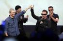 FILE - In this Sept. 9, 2014 file photo, Apple CEO Tim Cook, left, greets Bono from the band U2 after they preformed at the end of the Apple event on Tuesday, Sept. 9, 2014, in Cupertino, Calif. Apple unveiled a new Apple Watch, the iPhone 6 and Apple Pay and U2 offered iTunes customers a free download of their latest album, "Songs of Innocence." (AP Photo/Marcio Jose Sanchez)