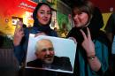 Iranian women hold a portrait of Foreign Minister Mohammad Javad Zarif and flash a victory sign during celebrations in Tehran on July 14, 2015, after Iran struck a nuclear deal with world powers