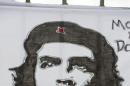 The iconic tongue symbol of the Rolling Stones sits atop the similarly iconic image of revolutionary hero Ernesto "Che" Guevara on a sign placed by fans outside the venue where the Rolling Stones will play their concert in Havana, Cuba, Friday, March 25, 2016. The Stones are performing in a free concert in Havana Friday, becoming the most famous act to play Cuba since its 1959 revolution.(AP Photo/Desmond Boylan)