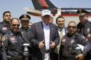 Republican presidential candidate Donald Trump poses with policemen, as he departs Laredo, Texas