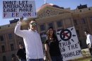 Two demonstrators opposing the pro gun and second amendment protest hold signs outside the Arizona State Capitol in Phoenix, Arizona