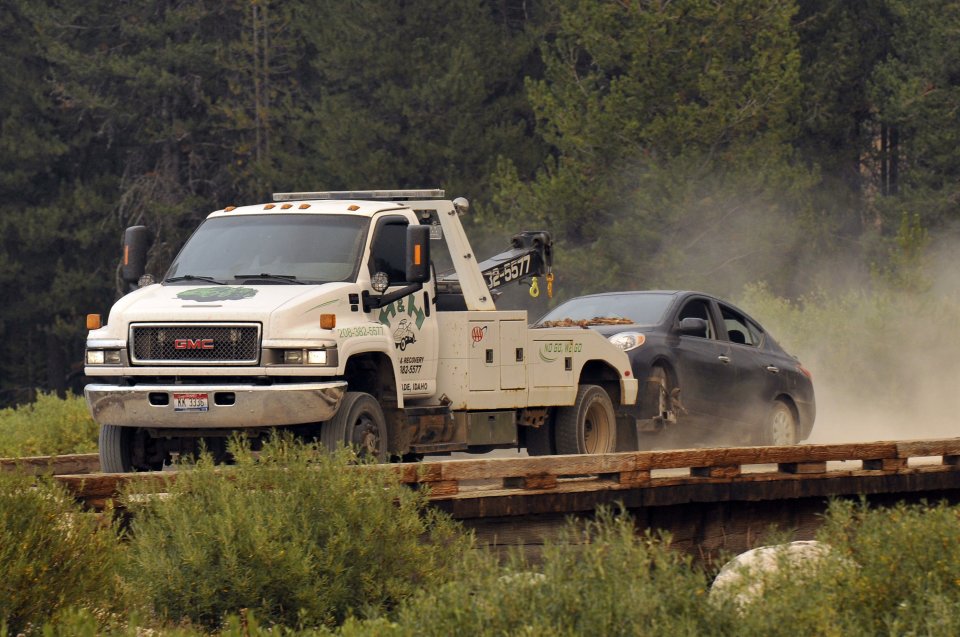 James Dimaggio's car is towed to the town of Cascade after dectives finished searsching it on a trail head bordering the Frank Church River of No Return Wilderness on Saturday, Aug. 10, 2013. Dimaggio, 40, is suspected of killing a California woman and her young son and then fleeing with the 16-year-old daughter was found in the Idaho wilderness on Friday after horseback riders reported seeing the man and girl hiking in the area two days earlier, authorities said. (AP Photo/Robby Milo)