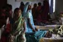 Bai, who underwent a sterilisation surgery at a government mass sterilisation camp, watches while other women sit inside a hospital at Bilaspur district in Chhattisgarh