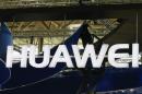 A worker adjusts the logo at the stand of Huawei at the CeBIT trade fair in Hanover