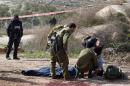 An injured Palestinian suspected attacker is treated by Israeli medic soldiers after he was shot following a stabbing attack on January 18, 2016 in the Tekoa settlement, south of Jerusalem