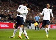 England's Andros Townsend (L) celebrates with Danny Welbeck (2nd L) during their World Cup qualifying match against Montenegro in north London on October 11, 2013