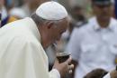 Pope Francis drinks from a mate gourd, a traditional South American cup, he was offered as he arrived for his weekly general audience, in St. Peter's Square, at the Vatican, Wednesday, Sept. 17, 2014. (AP Photo/Andrew Medichini)