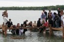 In this photo provided by Susan Orne, a group of Wisconsin high school students make their way out of the waist-deep water after a pier they were posing for photos prior to their prom collapsed, sending about half of the 18 students on the pier into a lake, in Oconomowoc, Wis. on Saturday, May 5, 2012. The kids sloshed toward one student's home, where they all broke out the towels, hair dryers and clothes dryers. Everyone made the big event, and Orne says the incident has provided them a memory they'll all enjoy at their 50th reunion. (AP Photo/Courtesy Susan Orne)