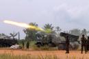 An armored vehicle of the FARDC, the Democratic Republic of Congo governmental troops, throws a missile during a fight against rebels of ADF-Nalu, near Kokola, 50km from Beni, January 18, 2014